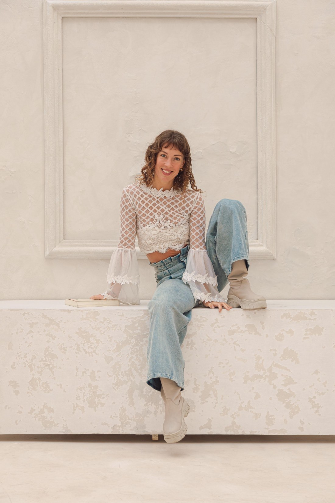 Ceci, fundadora de Omanada, sentada sobre un banco, sonriendo a cámara.
